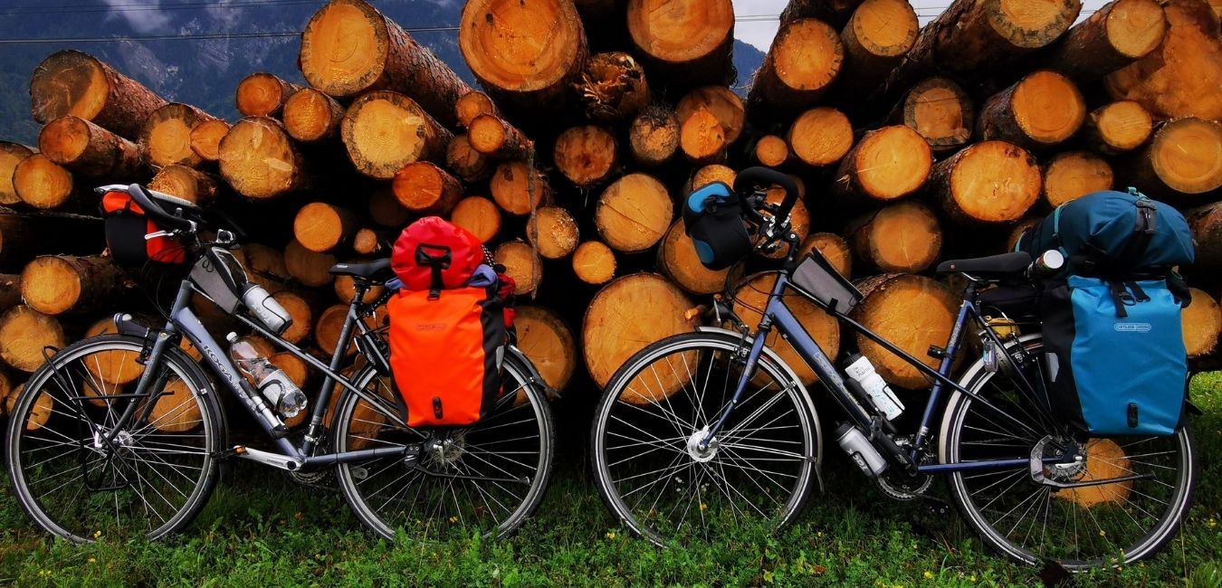 Best Bike Panniers attached to two tour bikes standing against a pile of wood